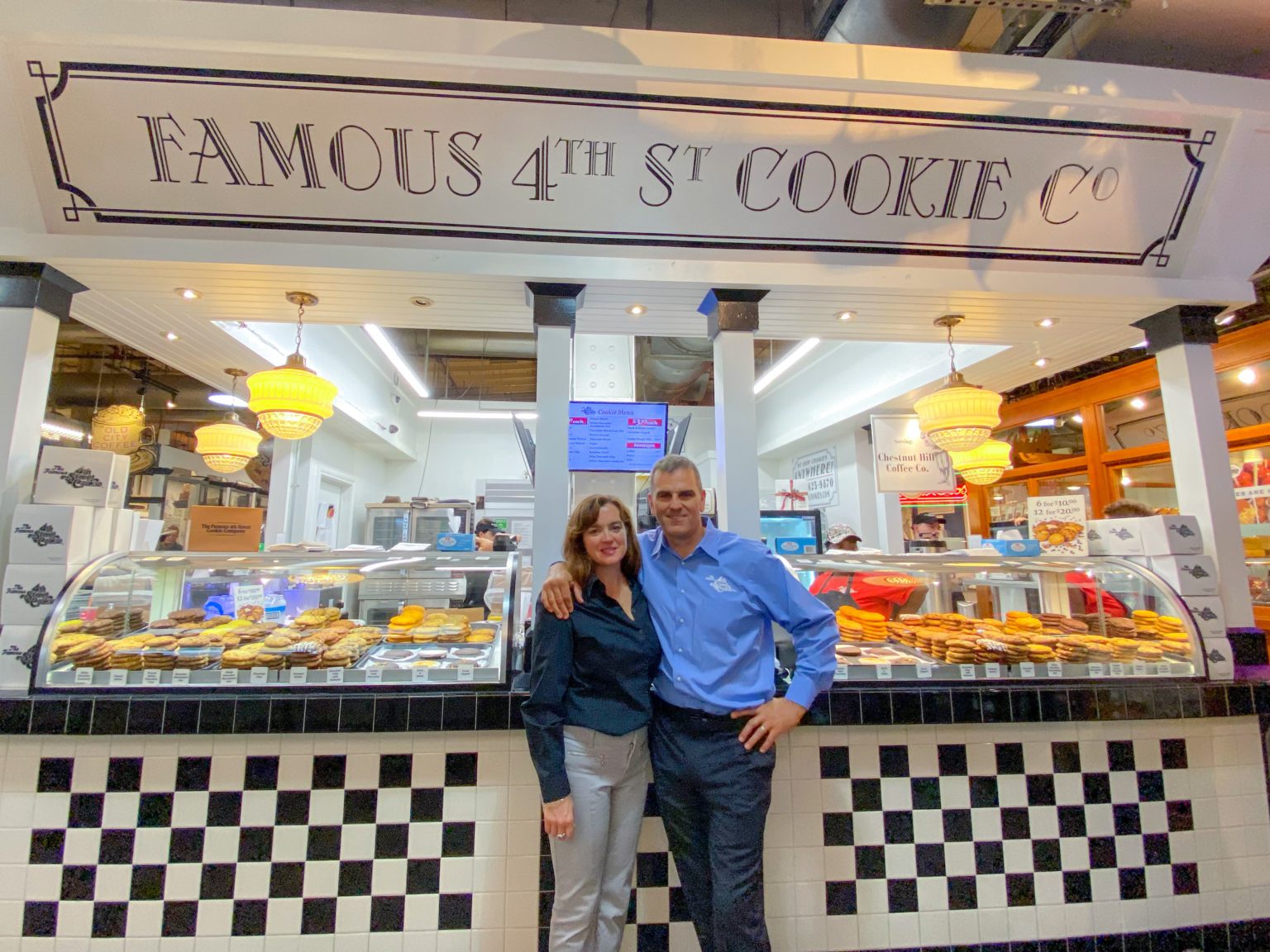 Photo of Brian and Tina Phillips in front of the Famous 4th St. Cookie booth at Reading Terminal Market